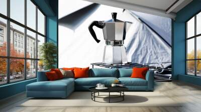 Close-up of an Italian coffee Moka pot on the portable gas stove for camping with a camping tent in the background. Making coffee outdoor in nature. Wall mural