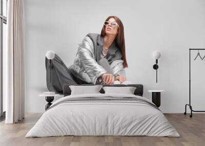 Fashion asian female model in silver down jacket and grey suit. Wall mural