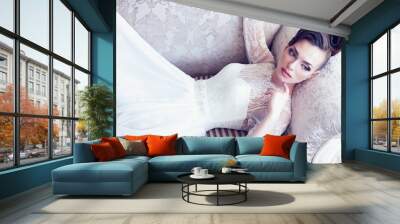 Young gorgeous bride is lying in antique couch Wall mural