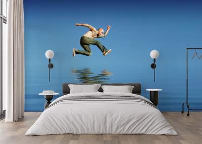 athletic man jumping on water Wall mural