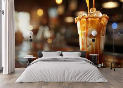 A fresh glass of iced coffee latte mix milk drink is placed on a wooden table. Wall mural