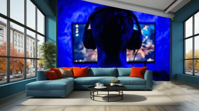 Gaming player looking into powerful computer, playing virtual shooter game late at night. Online streaming cyber stream during gaming tournament, using wireless technology network Wall mural