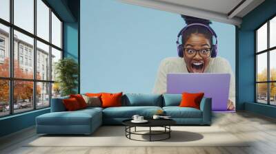 On a laptop, a smiling female gamer wins an online game Wall mural