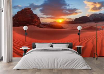 The red sand desert landscape with rocky mountain range in bright sunlight under a cloudy blue sky at the end of a hot dry day Wall mural