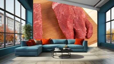 Sliced raw beef on cutting board and vegetables Wall mural