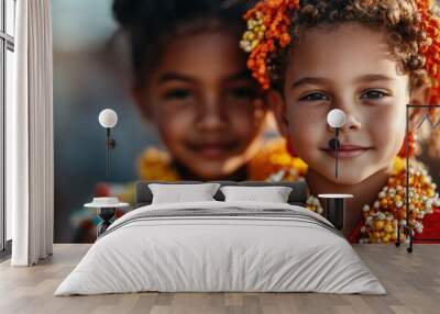 A close look at two smiling children in vibrant traditional wear adorned with flowers, demonstrating diversity and cultural beauty on a sunny day. Wall mural