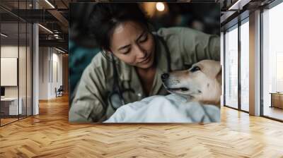 A devoted female veterinarian in professional attire attentively cares for a dog lying on a table. Her facial expression shows genuine affection and dedication to animal welfare. Wall mural