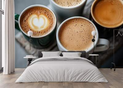 A selection of coffee mugs adorned with intricate latte art sits atop a rustic wooden table, highlighting the warmth and artistry associated with coffee culture. Wall mural