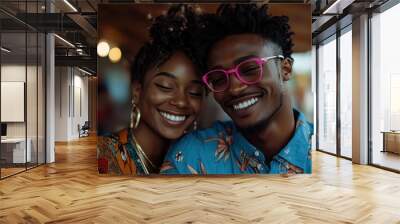 A smiling couple enjoys a sunny outdoor setting, with the man wearing bright pink glasses and both dressed in colorful floral shirts, capturing a moment of happiness and togetherness. Wall mural