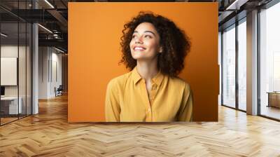 Smile in Contemplation: Joyful Young Woman Poses in Studio, Lost in Thought Wall mural