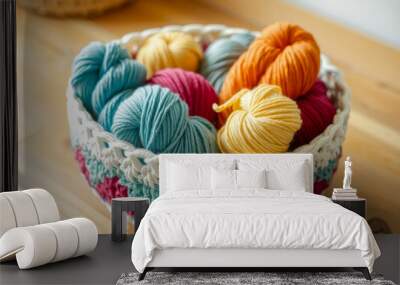 A basket of colorful yarn is sitting on a wooden table. The yarn is in various colors, including blue, green, yellow, and orange. The basket is arranged in a way that makes it look like a colorful Wall mural