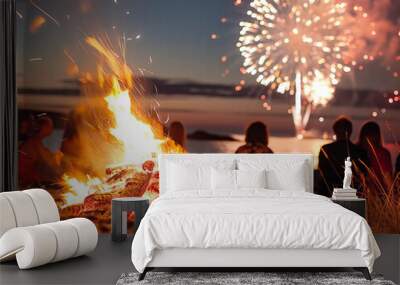 A group of people are sitting around a fire on a beach, with fireworks in the background. Scene is festive and relaxed, as the group enjoys the warmth of the fire and the beauty of the fireworks Wall mural