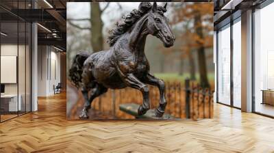 A horse statue is shown in mid-jump, with its legs spread wide and its head lifted high. The statue is made of bronze and is placed on a bench. The scene has a sense of motion and energy Wall mural