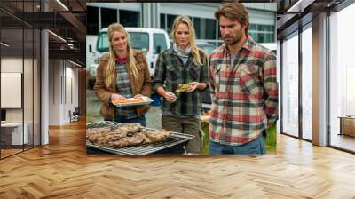 Three people are gathered around a grill, with one man looking at the food. Scene is casual and relaxed, as the group is enjoying a barbecue together Wall mural