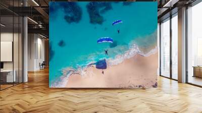 Two people are flying a parachute over the ocean. The sky is blue and the water is calm Wall mural