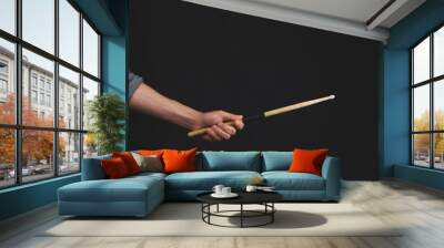 Hand holds drumstick in the dark. copy space Wall mural