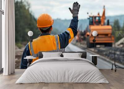 A road construction engineer is waving his hand to show signs while machinery is working. Wall mural