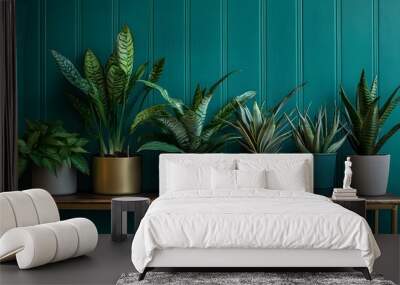 A variety of potted plants on wooden tables against an emerald green wall, creating a vibrant and fresh indoor garden setting with an abundance of plant life Wall mural