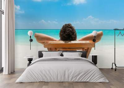 Man relaxing on beach Wall mural