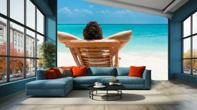 Young man resting on beach Wall mural