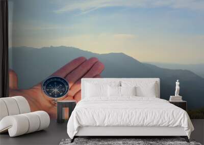 Compass in hand in mountains during Hiking. Tourist compass for orientation on terrain. Magnetic declination сalculator. Map reading and land navigation concept. Orient on maps in Spain mountains. Wall mural