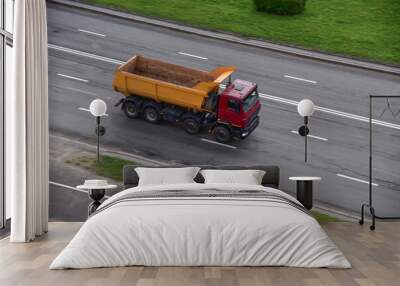 Dump truck carries sand along a road in a city. View from above. Object in motion, soft focus, possible graininess Wall mural