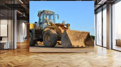 Front-end loader working on construction site during the renovation of the road. Wall mural