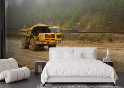 Heavy large quarry dump truck. Big wheels. The work of construction equipment in the mining industry. Production useful minerals. Sand transportation. Coal mine. Wall mural