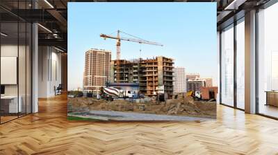 Heavy mixer concrete truck waiting for to be loaded concrete at construction site. Tower crane constructing house. Building projects in residential, institutional, commercial and industrial sectors Wall mural