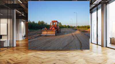 Roadworks. Motor Grader on road construction in forest. Greyder leveling the ground during roadworks. Heavy machinery and construction equipment for grading. Earthworks grader machine on Roadworks. Wall mural