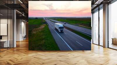 Truck with semi-trailer driving along highway on sunset background. Goods Delivery by roads. Services and Transport logistics. Traffic on road. Shipping, Import - Export. Wall mural