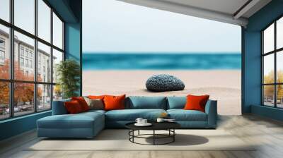 smooth stone on sandy beach with ocean background Wall mural