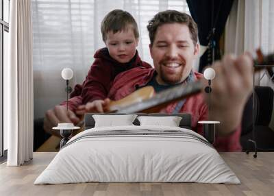 father teaching son how to play guitar Wall mural