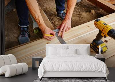 man drilling and measuring wood for deck Wall mural