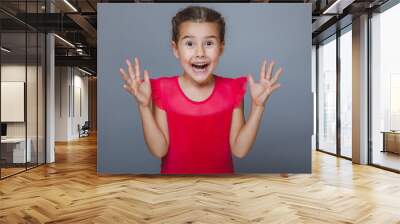 girl child holding hands at the mouth surprised on a gray backgr Wall mural