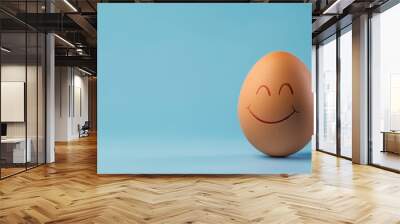 A single brown egg with a happy face drawn in black marker, placed on a bright blue background with ample copy space. Wall mural