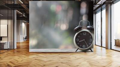 Clock with Arabic numeral on clockwise put on the rock in the green garden with natural bokeh. Wall mural