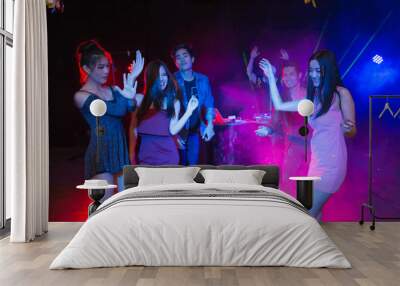 Holiday travel celebrations concept, group of people dancing together with enjoying at colourful night party club. Wall mural