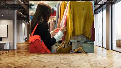 Shopper woman buying clothes in the shopping center shop. Wall mural