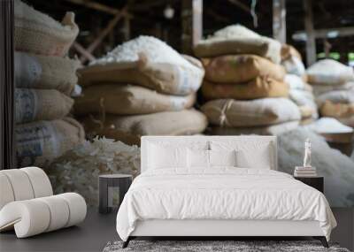 Stacks of sacks filled with white rice sit in a warehouse. Wall mural