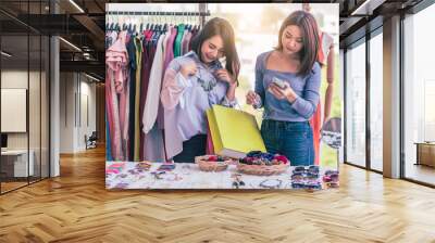 Young travel shopping woman choosing clothes with shop owner service at clothes shopping mall centre.	 Wall mural