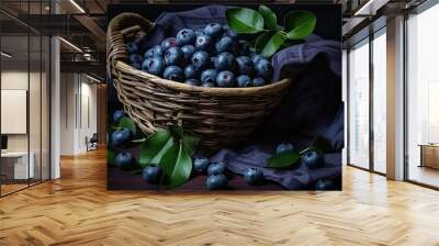 Close-up of ripe blueberries and leaves in a basket on a dark table with a dark clothar Wall mural