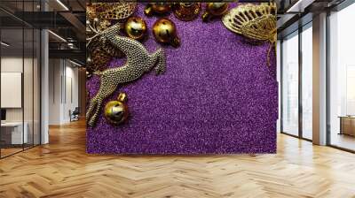 Gold Christmas balls and gold Elk Christmas ornaments with space copy on Purple glitter background Wall mural