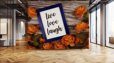 Love Live Laugh typography text with flower decoation on wooden background Wall mural