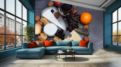 Glass of red wine with cheese, grapes and apples on grey background with copy pace.  Wall mural