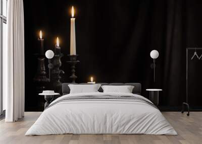 antique candlestick with burning candle on old wooden table on background black velvet curtain Wall mural