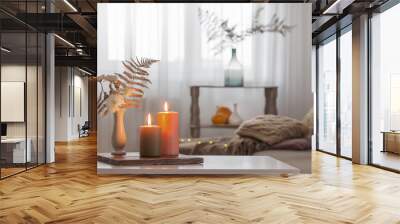 burning candles with autumn decor on white table at home Wall mural