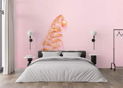 Christmas tree of painted golden leaves fern on pink paper backg Wall mural