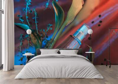 flowers essential cosmetic product bottle with  flowers and on blue and red  background, top view Wall mural