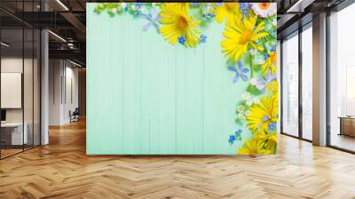 frame of beautiful flowers on green wooden background Wall mural